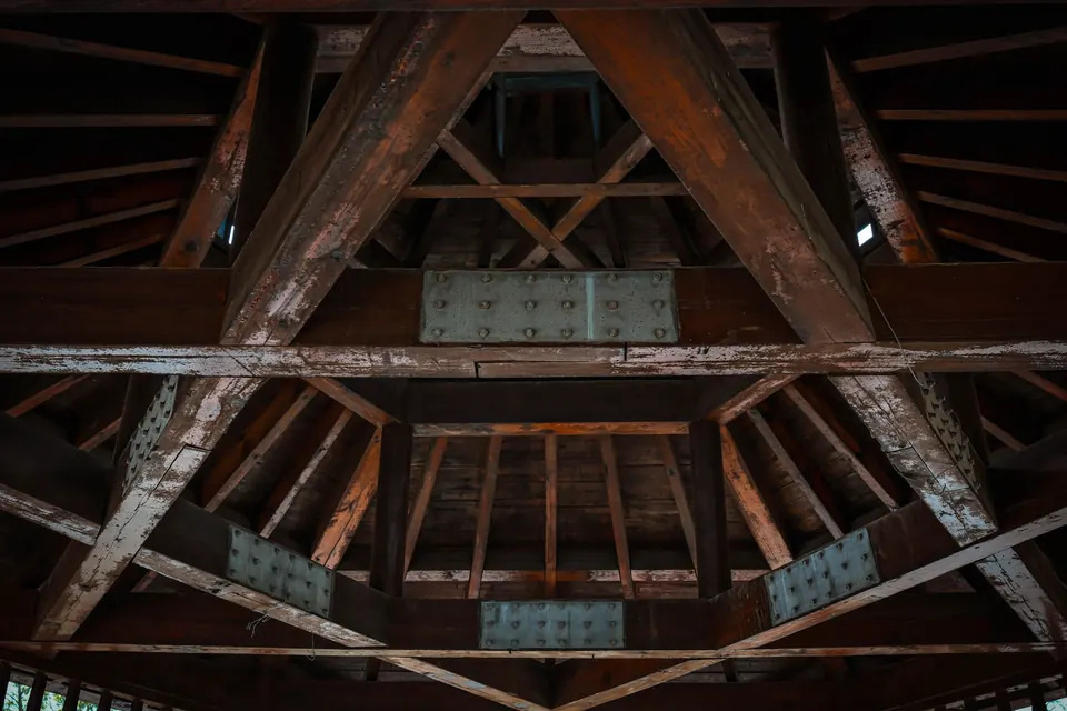 Charpente en bois vue de dessous : arbalétriers, entrait et assemblages renforcés de platines